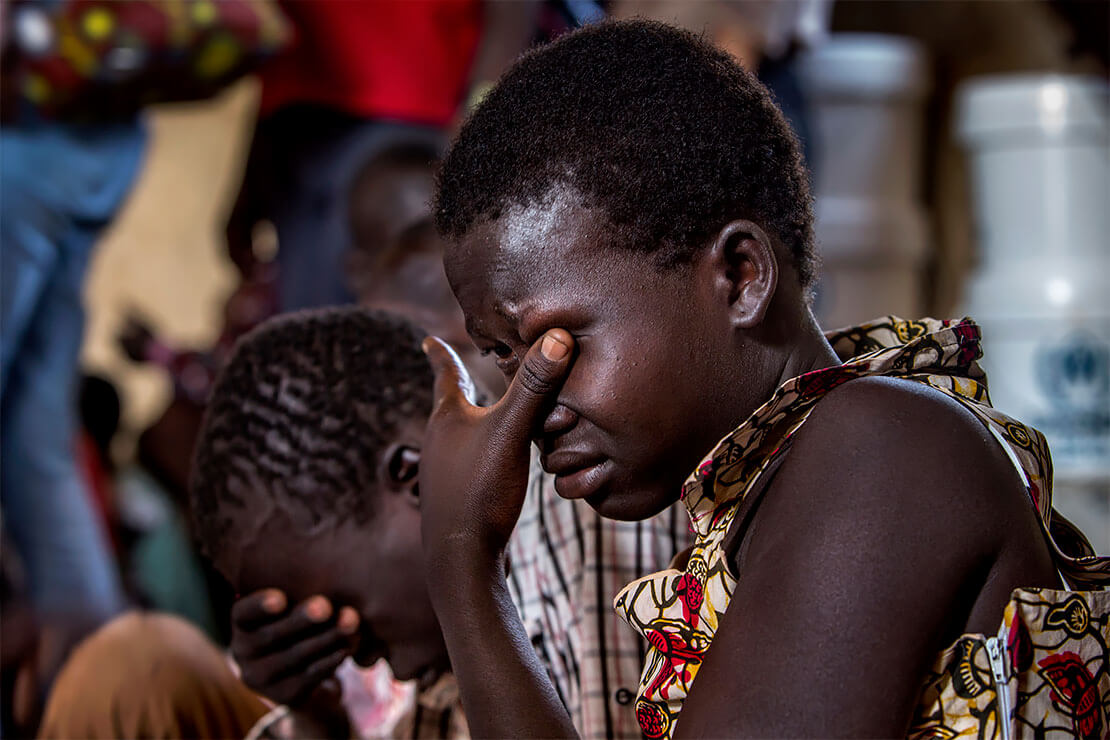 Elizabeth Aguek Lino, 16, cries as she recounts to Refugees Chief Filippo Grandi how her father and brother were shot and killed in South Sudan. <p>© Georgina Goodwin</p>