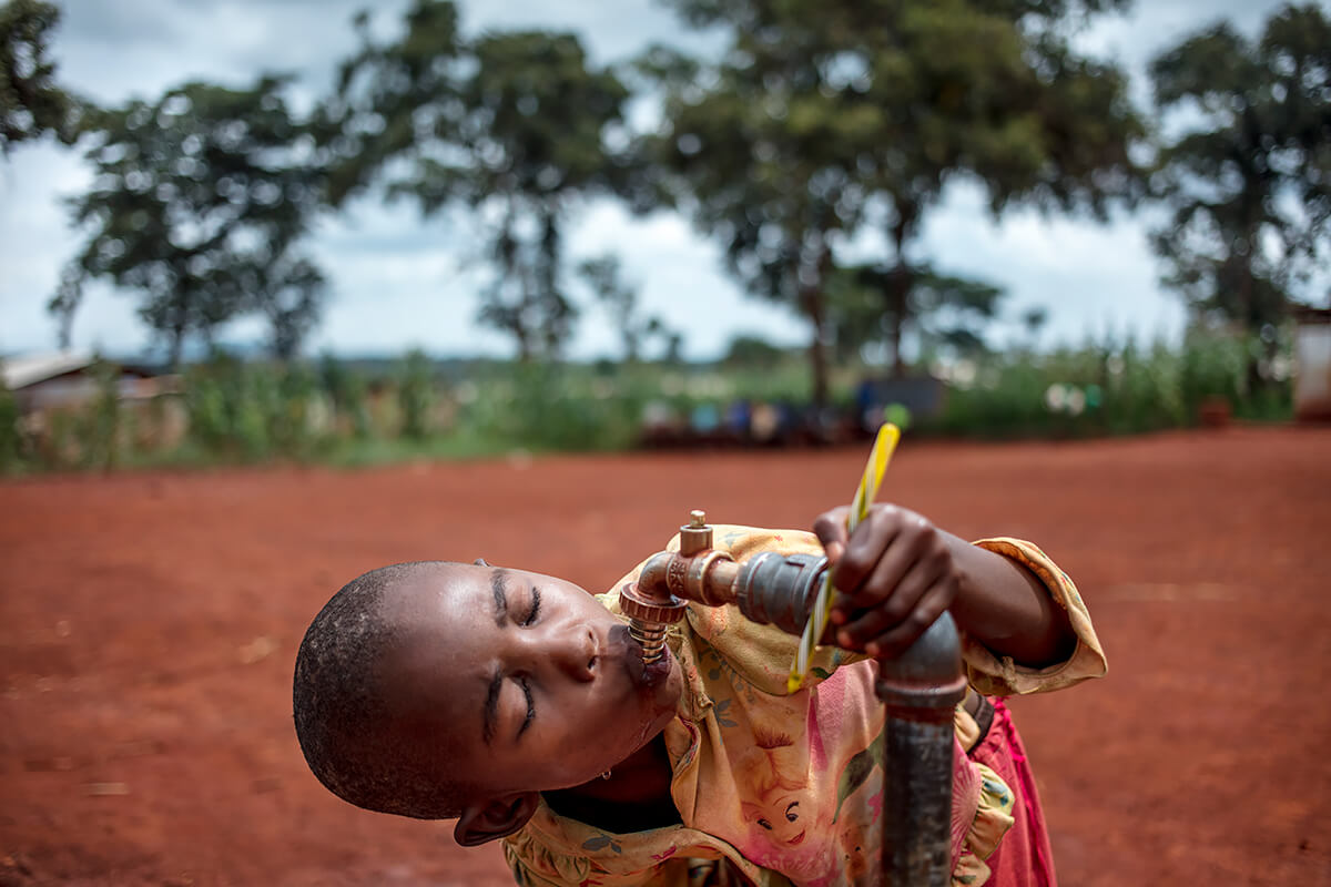 Burundi refugee students drink from the tap at Jugudi Primary School at Nyarugusu Refugee Camp in Kasulu District, western Tanzania, 2019<p>© Georgina Goodwin</p>